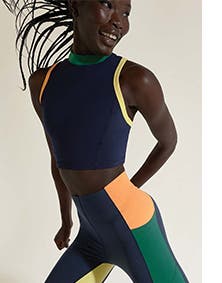 Woman wearing color-blocked cropped tank and leggings active set.